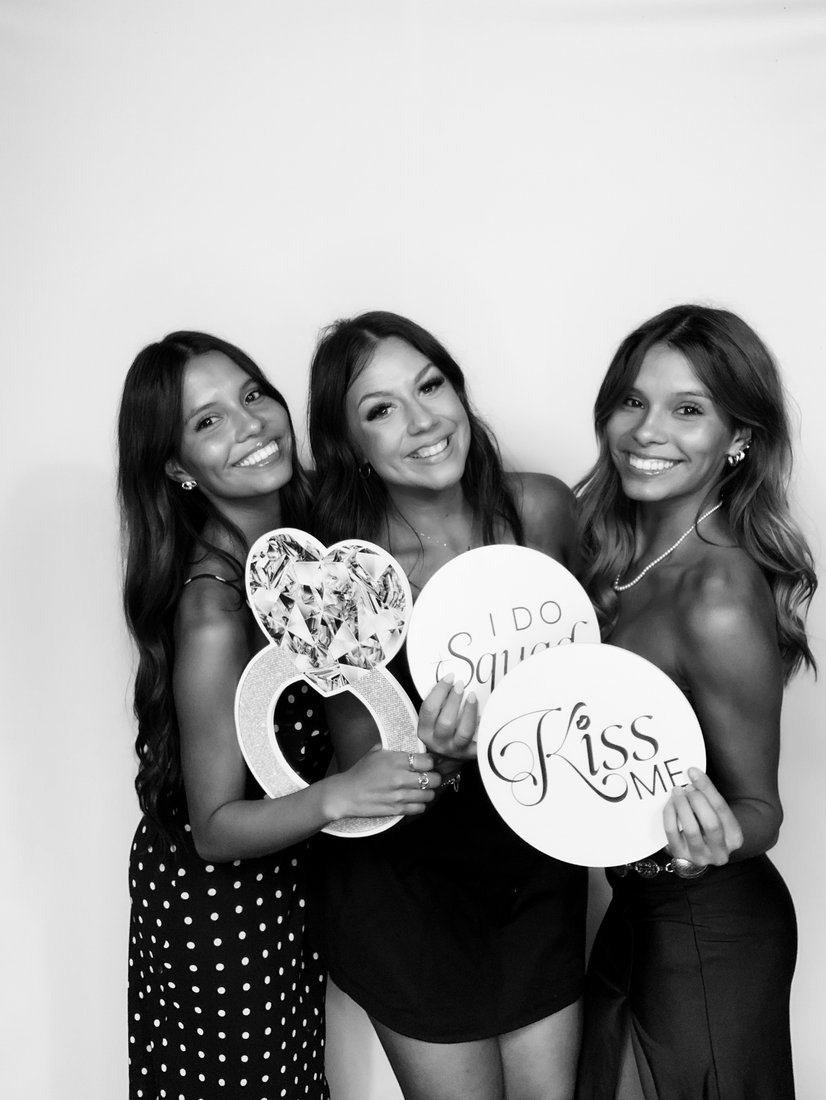 Guests smiling with props in photo booth